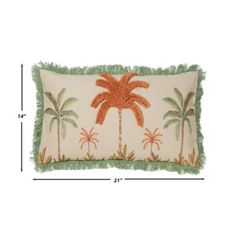 a pillow with palm trees on it and fringe trimming around the edges is shown