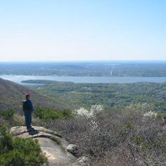 a man standing on top of a mountain overlooking a lake