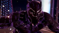 the black panther is standing in front of a building at night with its hands on his hips