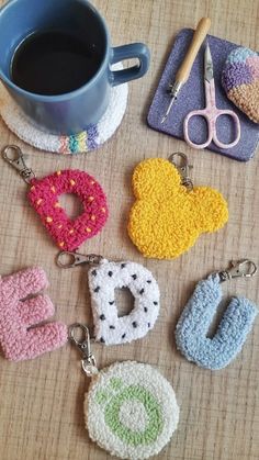 crocheted keychains are sitting on a table next to a cup of coffee