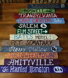 a wooden table topped with lots of different colored signs