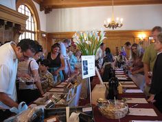 a group of people standing around a long table