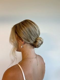 a woman with blonde hair wearing a white top and gold earrings on her left ear