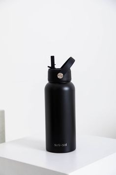 a black water bottle sitting on top of a white table