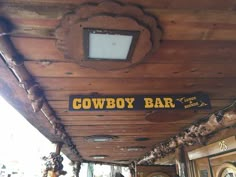 there is a cowboy bar sign on the ceiling