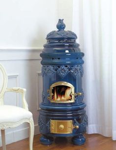 a blue stove sitting on top of a hard wood floor next to a white chair