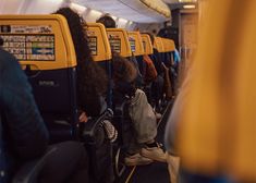 people sitting on seats in an airplane with their backs turned to the side as they travel