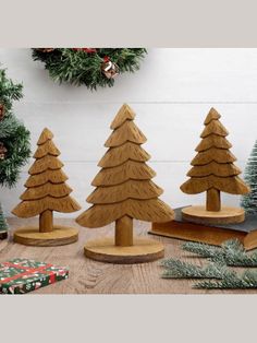 wooden christmas trees on display in front of a wreath