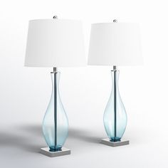 two blue glass vases with white lamps on them