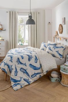 a bed room with a neatly made bed next to a window and a basket on the floor