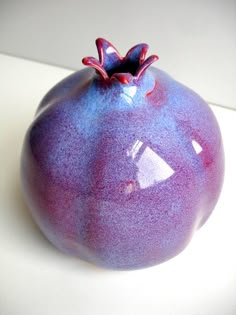 a blue and purple vase sitting on top of a white table