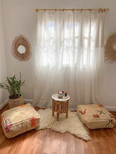 a living room with two stools and a table in front of a curtained window