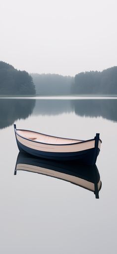 a small boat floating on top of a large body of water with trees in the background