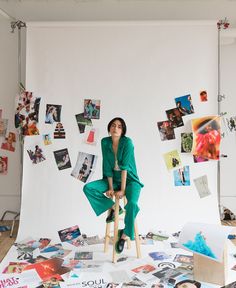 a woman sitting on top of a chair surrounded by pictures