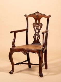 an old wooden chair sitting on top of a white floor next to a beige wall