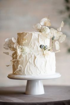 a white wedding cake with flowers on top