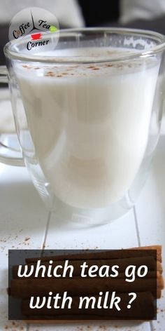 a glass cup filled with milk next to cinnamon sticks