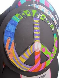 a peace sign made out of paper on top of a black object with colorful designs