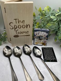 four spoons are sitting in front of a wooden box with the spoon game on it