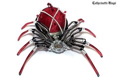 a red and black spider sculpture sitting on top of a white table