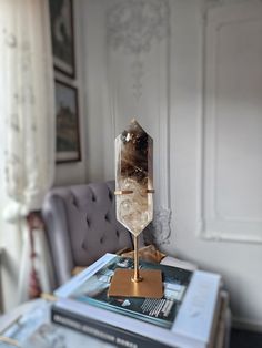 a table topped with a crystal sculpture on top of a wooden table next to a gray chair