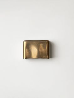 a gold rectangular object on a white surface