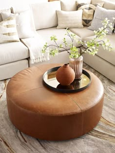 a living room filled with furniture and a vase on top of a coffee table in front of a couch