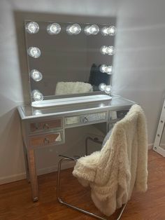 a dressing table with a mirror and lights on it