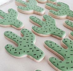 decorated cookies are arranged in the shape of cactuses