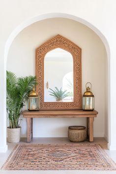 a wooden bench sitting under a mirror next to a potted plant