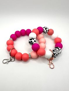 Finding your keys in your purse or bag can be frustrating, especially when you are trying to go somewhere.  Who has time to search for their keys.  With our Pink Cow designed keychain bracelet/wristlet, you can throw your worries away and attach your keys to this stunning design. Each keychain is made with high quality silicone beads.  Designed to slide on your wrist with ease (depending on your wrist size of course).  Attach your keys to the metal ringed lobster clasp.  Each bracelet is put tog Handmade Pink Bracelet For Everyday Use, Trendy Beaded Wristlet For Everyday Use, Handmade Pink Bracelet For Everyday, White Round Beads Bracelets For Everyday Use, Everyday White Round Bead Bracelets, White Round Beads Keychains For Everyday Use, Handmade Trendy Wristlet For Everyday Use, Trendy Handmade Wristlet For Everyday, Trendy Pink Wristlet With Keychain