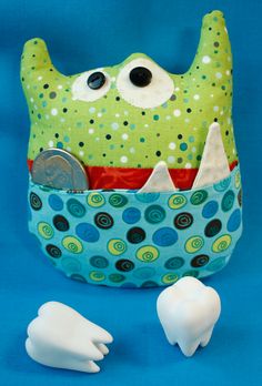 a toothbrush holder with two teeth and a coin in it, on a blue background