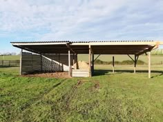 a horse barn with an open roof and stairs leading up to the top of it