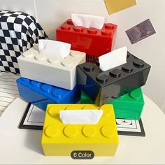 four legos are stacked on top of each other in different colors and shapes,