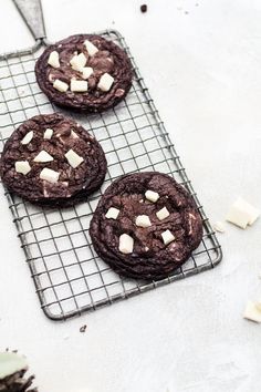 three chocolate cookies with marshmallows on a cooling rack