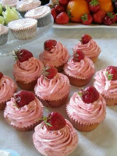 cupcakes with pink frosting and strawberries on top