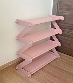 a pink shelf sitting on top of a wooden floor