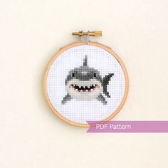 a cross - stitch pattern of a shark with a smile on it's face