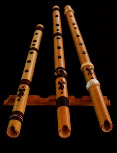 four wooden flutes are lined up in a row