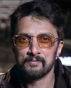 a close up of a person wearing glasses with a beard and moustache on