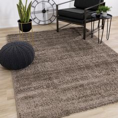 a living room area with a chair, rug and clock on the wall behind it