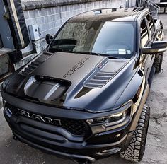 a black truck parked next to a brick wall