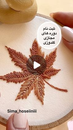 someone is working on an embroidered leaf