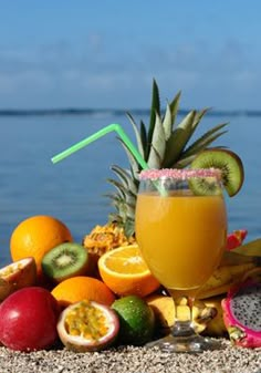 a tropical drink with fruit on the beach