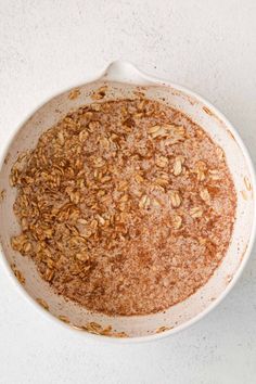 a white bowl filled with granola on top of a table