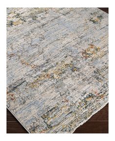 an area rug with various colors and patterns on the floor, including blue, yellow, orange