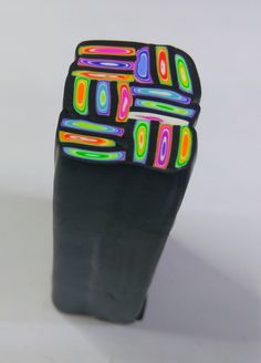 a black object with multicolored designs on it