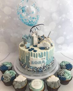 a blue and white birthday cake surrounded by cupcakes