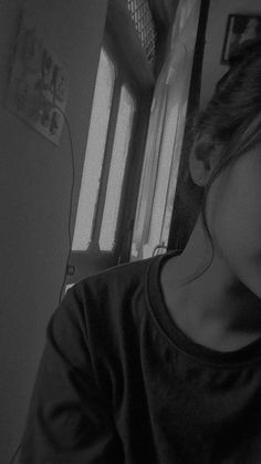 black and white photograph of a girl looking out the window