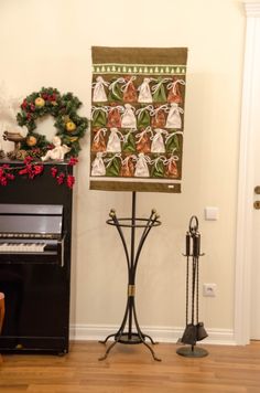 there is a piano in the living room next to a christmas wreath and other decorations